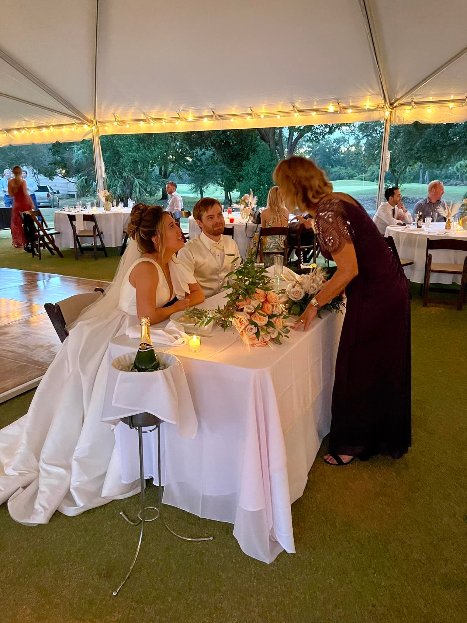 Bride and groom at sweetheart table at a tented reception, St. James Bay